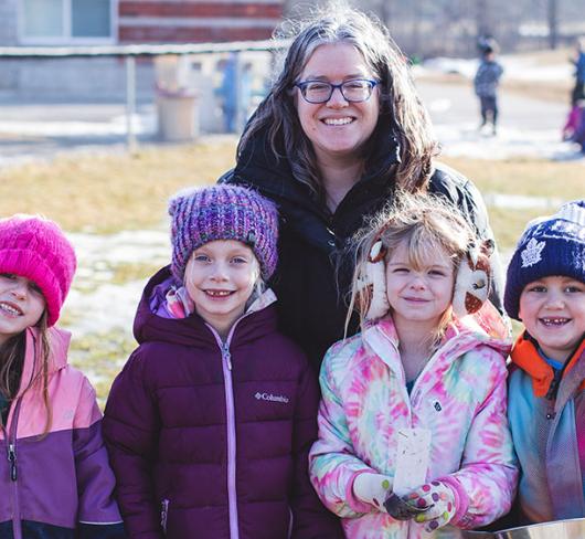 Christina Wilson posing with four children from class in a park