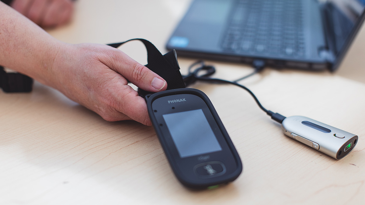 Rogers Touch Screen mic/ FM mic. Often used by teachers for their deaf students, Kim uses this in reverse, in a variety of settings. One to One, Small group, and staff meetings. It has also been utilized at occasional union events, workshops and meetings. It is connected by Bluetooth to the Rogers receiver, seen connected to the computer by usb.