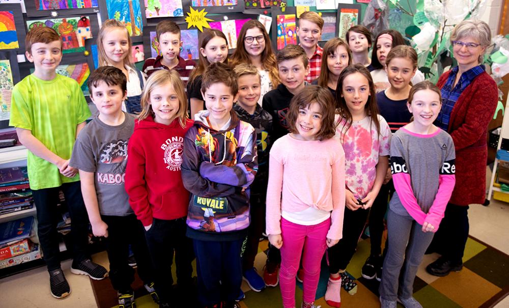 Children standing with teacher in classroom