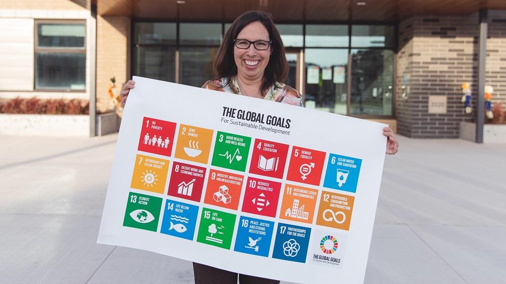 Woman holding poster with The Global Goals for Sustainable Development displayed
