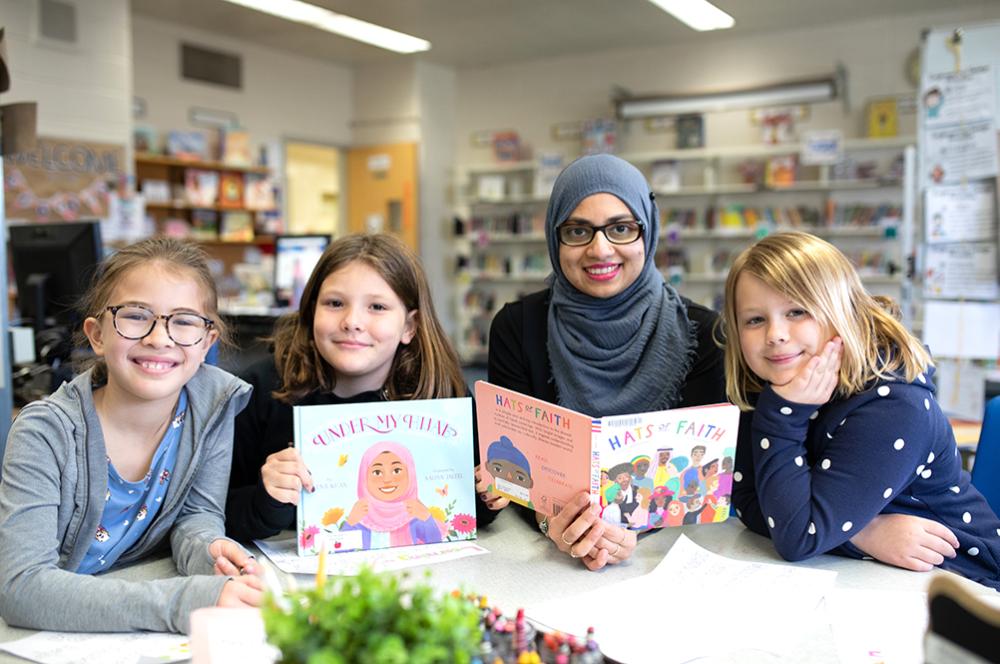 Teacher and students in classroom holding books