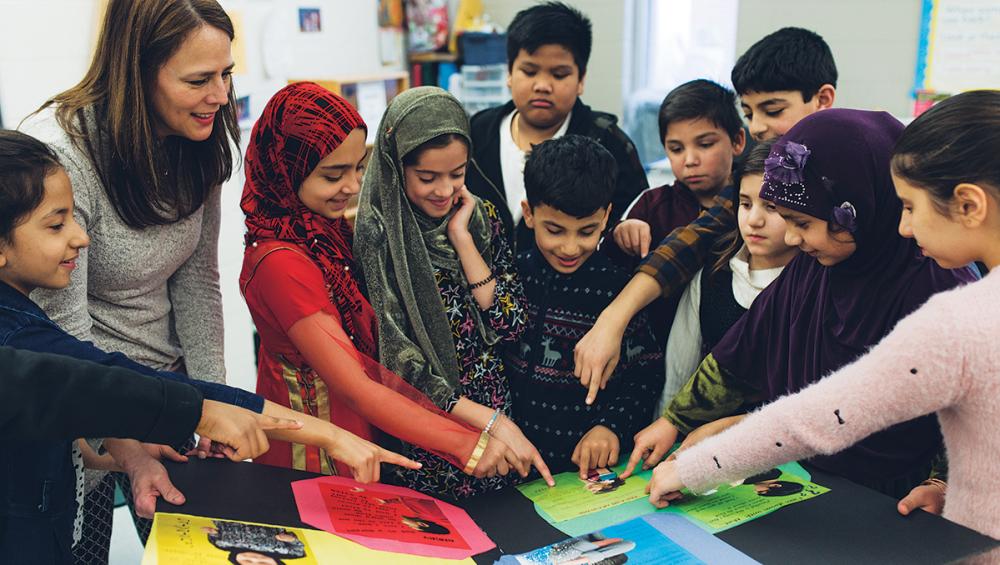 Children and teacher pointing at project