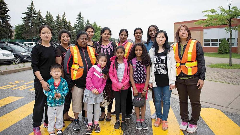 Students parents and faculty standing together in school parking lot