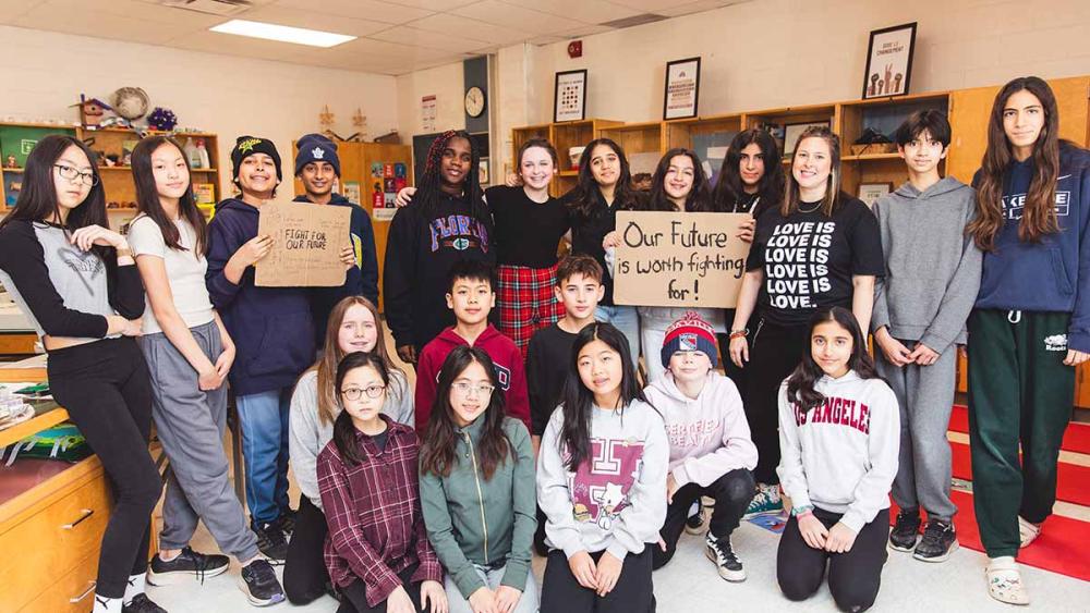 Students in classroom holding signs that promote activism