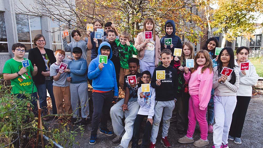 Jen Reid and her students standing outside holding cards