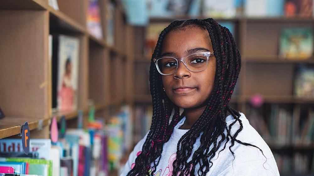 Black female student picking a book to read in the library