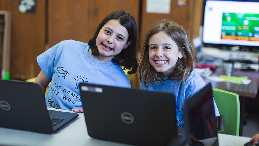 Two girls in classroom using a laptop