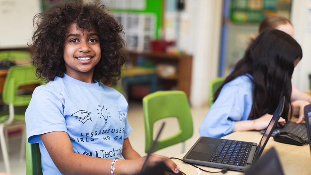 Young girl in classroom using a laptop