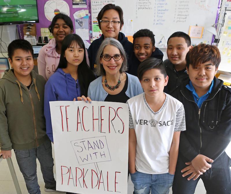 Teacher and students standing in class with political sign. Photo by Cheol Joon Baek