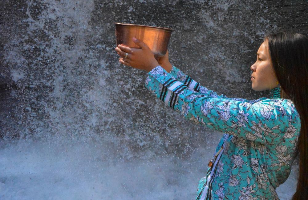 Autumn Peltier holding bowl near waterfall