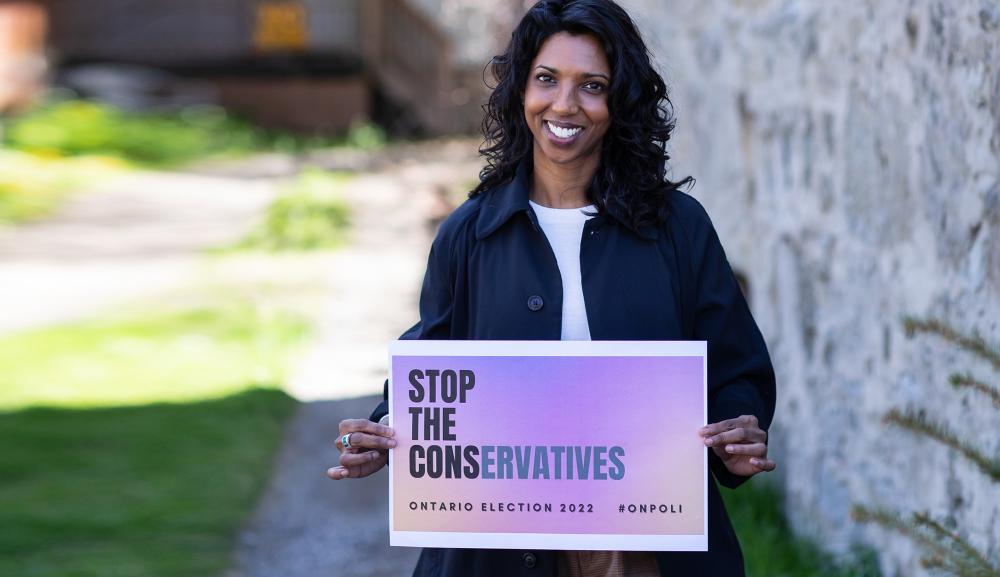 Cindy Gangaram holding "Stop the Conservatives" sign outside