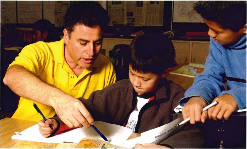 teacher showing elementary student in book