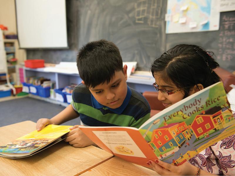 Refugee students reading a book in classroom