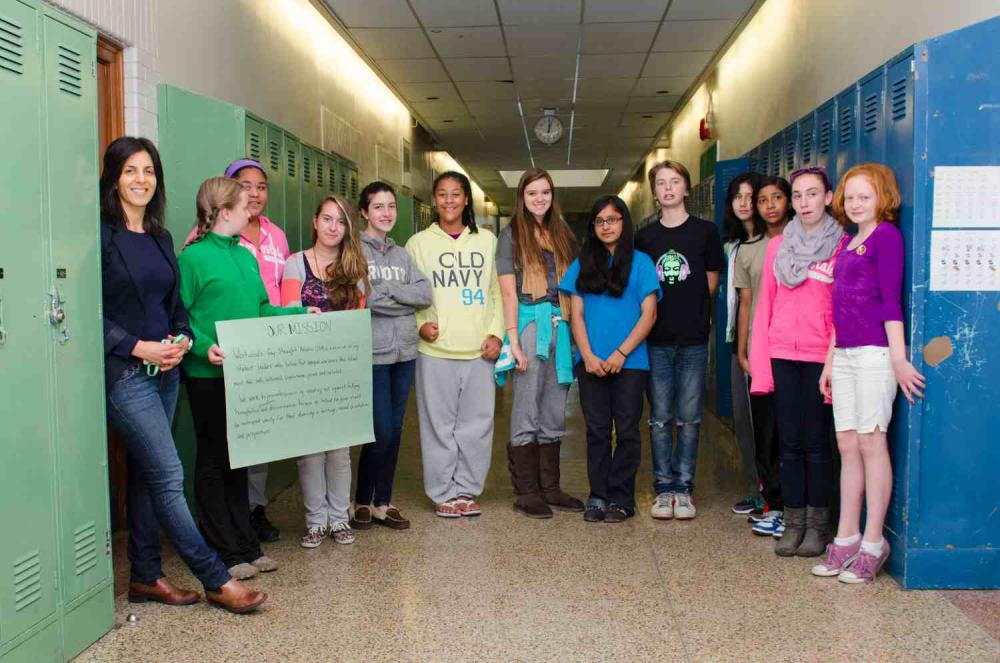 teacher and students standing in hallway between lockers
