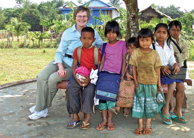 overseas teacher sitting with students outside