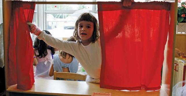 young girl opening red curtain 