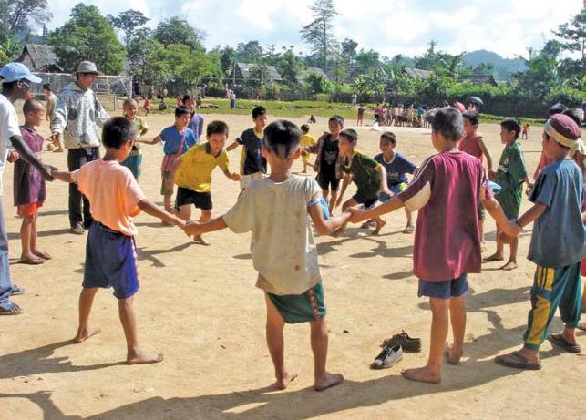 Young children holding hands in circle while two children chase one another within