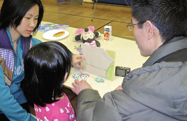 Parents with child looking at the child's work