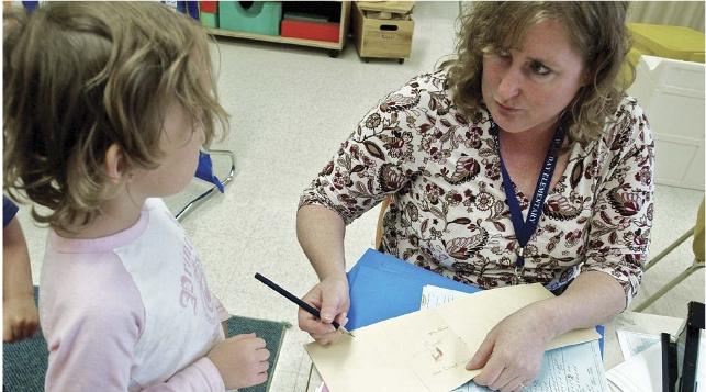 teacher working with kindergarten student