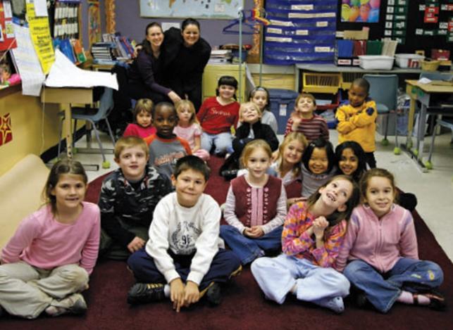 Young students sitting on carpet in classroom