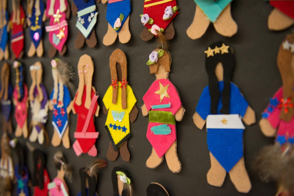 Student's dolls hanging on board