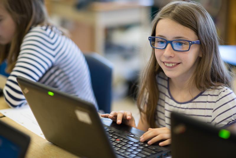 student using laptop and smiling