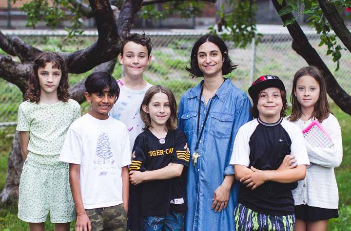 Gradeschoolers standing outside with their teacher