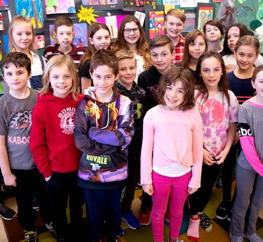 Children standing with teacher in classroom