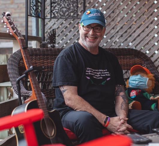 Gordon Nore on patio with guitar