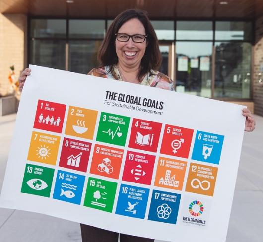 Woman holding poster with The Global Goals for Sustainable Development displayed