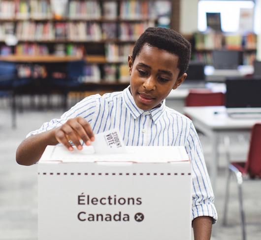 student placing voting card into elections box