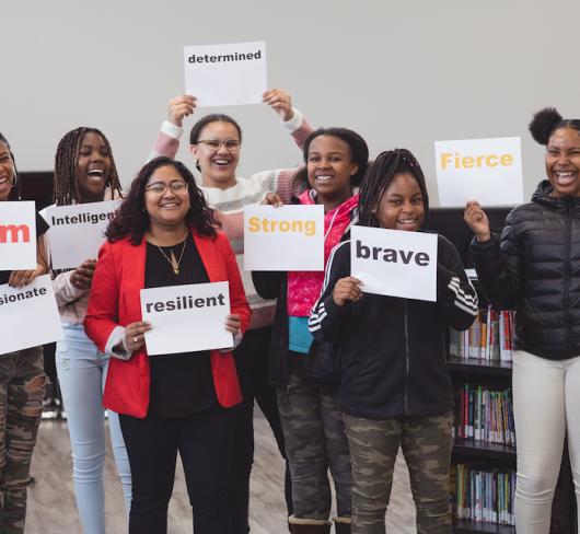 students holding inspirational signs