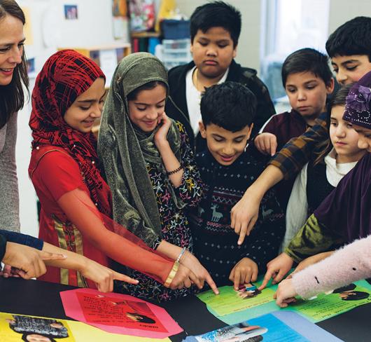 Children and teacher pointing at project