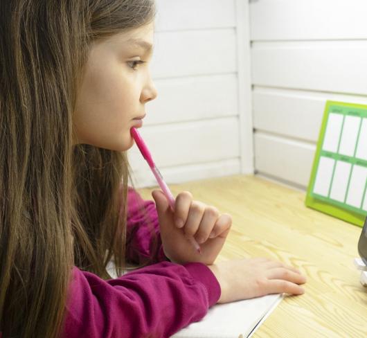 Young girl looking at tablet computer in classroom