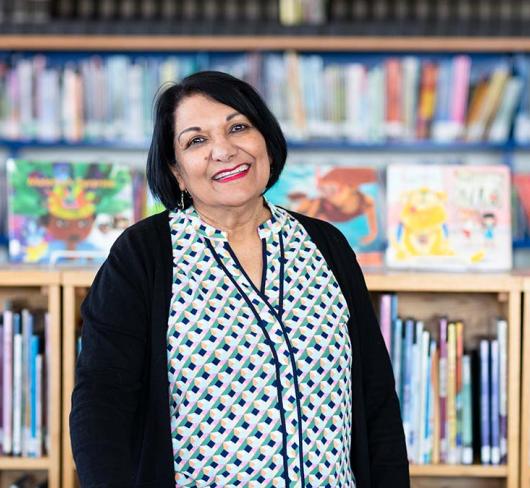 Shamim Murji standing in library of school