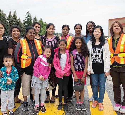 Students parents and faculty standing together in school parking lot