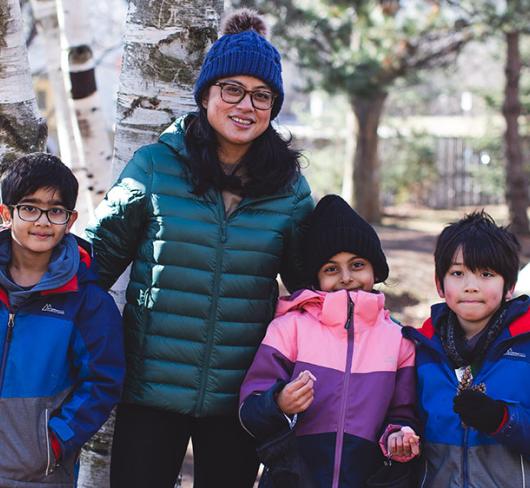 Colleen Elep standing with students outside in the winter