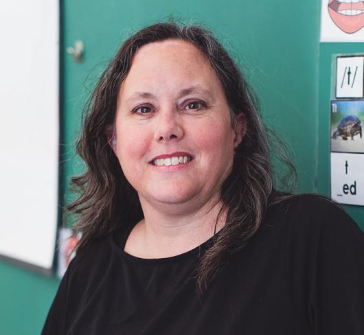 Kim Brown posing in front of classroom