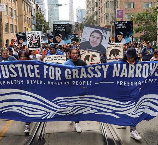 8,000 people marching from Toronto’s Grange Park to Queen’s Park in solidarity with members of Asubpeeschoseewagong (Grassy Narrows) First Nation.