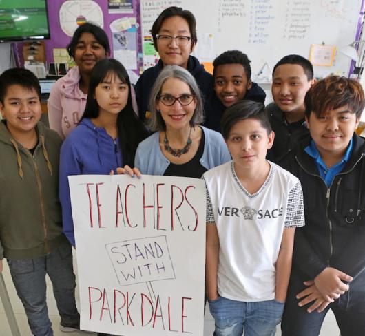 Teacher and students standing in class with political sign. Photo by Cheol Joon Baek