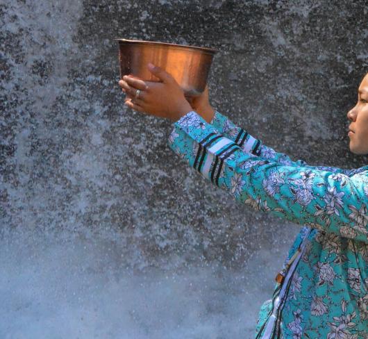 Autumn Peltier holding bowl near waterfall