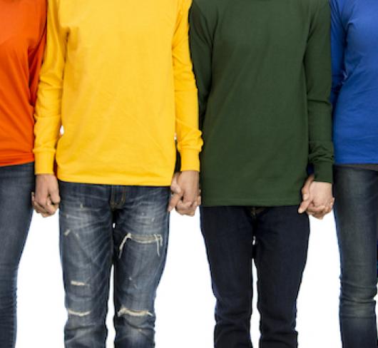 students wearing different colour shirts holding hands