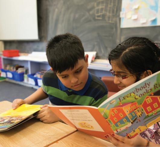 Refugee students reading a book in classroom