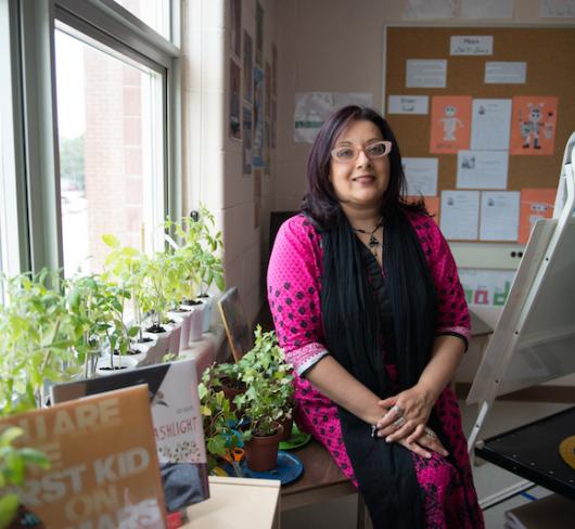 Zaiba Beg standing in classroom next to window and plants