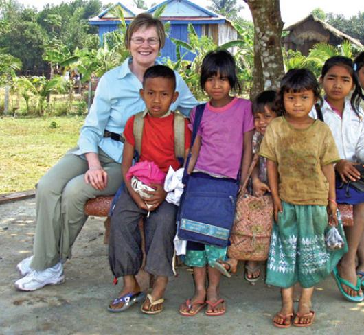 overseas teacher sitting with students outside