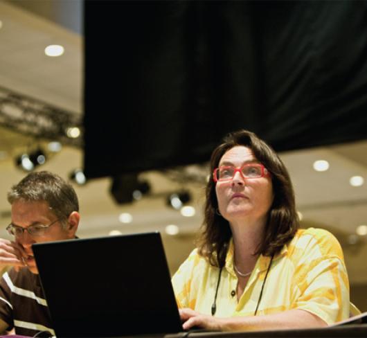 etfo members sitting at table with laptops watching speaker