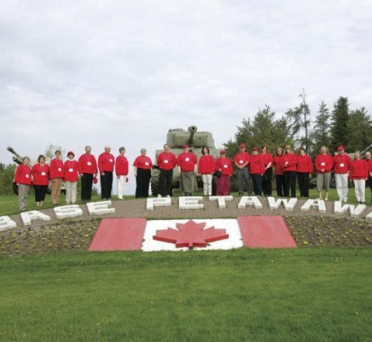 ETFO members wearing red posing next to Base Petawawa sign