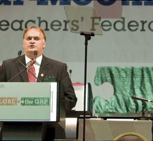 etfo member standing at podium speaking to crowd out of frame