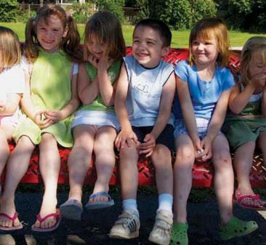 8 kindergarten students sitting on bench