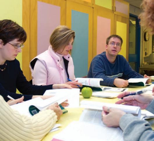 etfo members sitting around table discussing content in textbooks